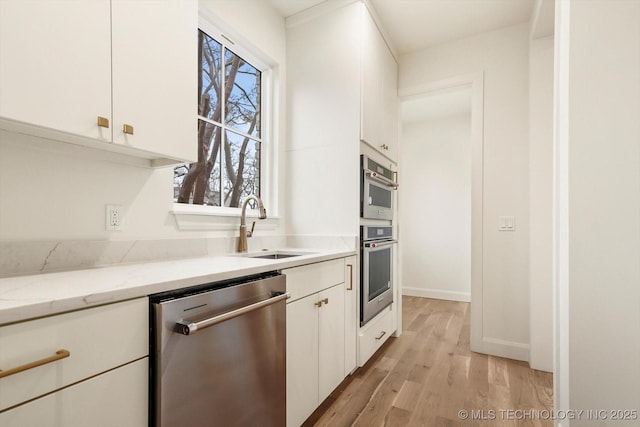 kitchen featuring white cabinetry, stainless steel appliances, and light stone counters