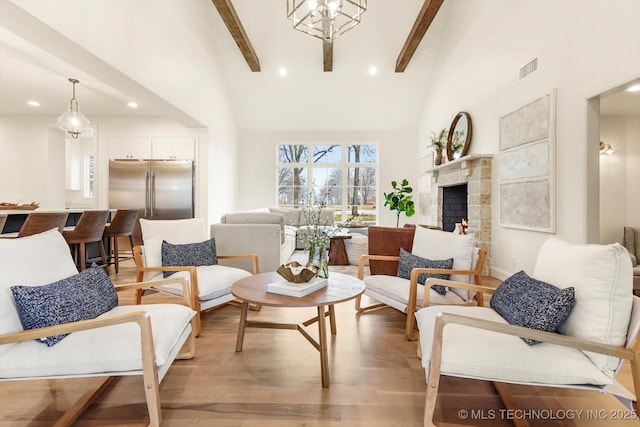 living room with high vaulted ceiling, beam ceiling, and light hardwood / wood-style floors