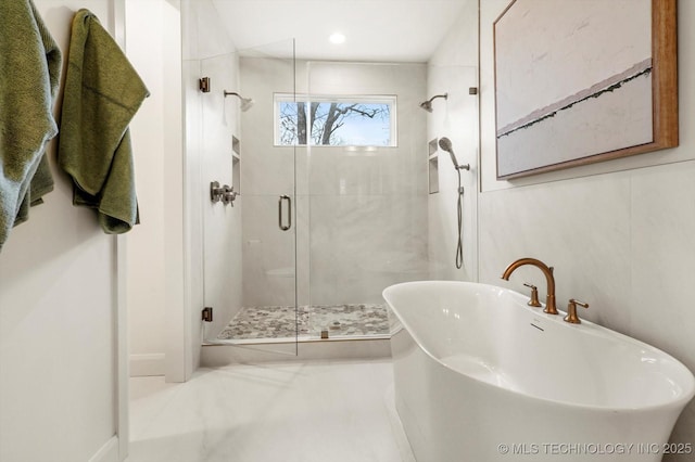 bathroom featuring shower with separate bathtub