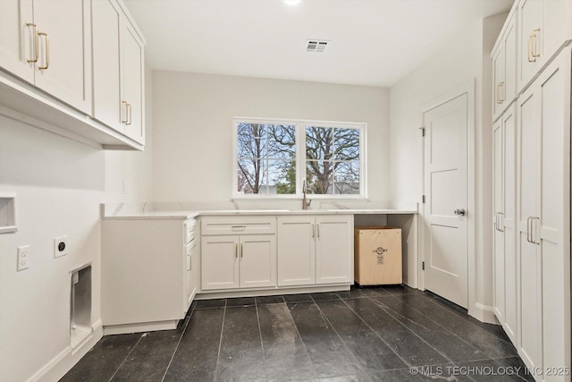 laundry area with cabinets, hookup for an electric dryer, and sink