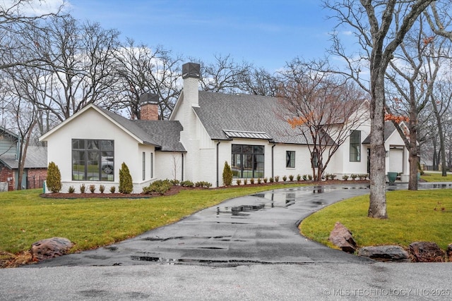 modern farmhouse style home featuring a garage and a front lawn