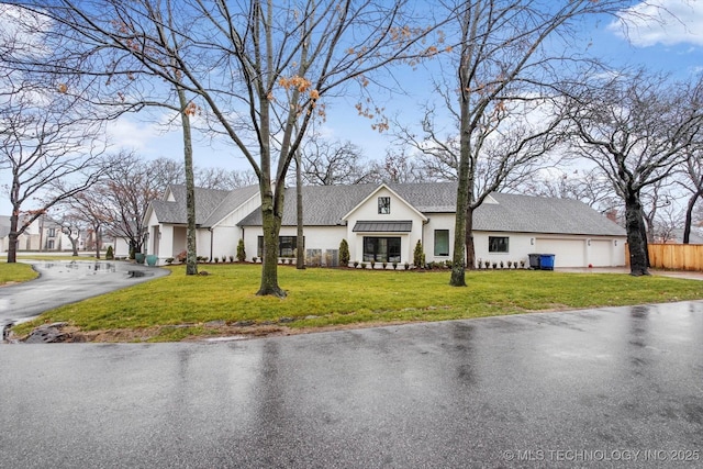 view of front of property featuring a garage and a front lawn