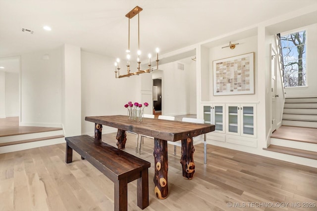 dining space featuring light hardwood / wood-style floors and a chandelier