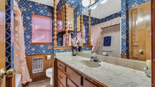 bathroom featuring vanity, toilet, and heating unit