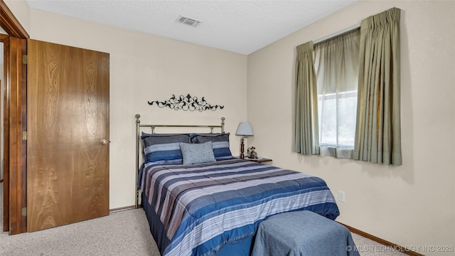 bedroom featuring a textured ceiling and carpet