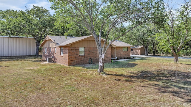 view of side of home with central AC and a lawn