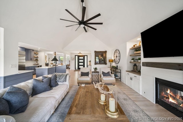 living room with high vaulted ceiling, ceiling fan, and light hardwood / wood-style flooring