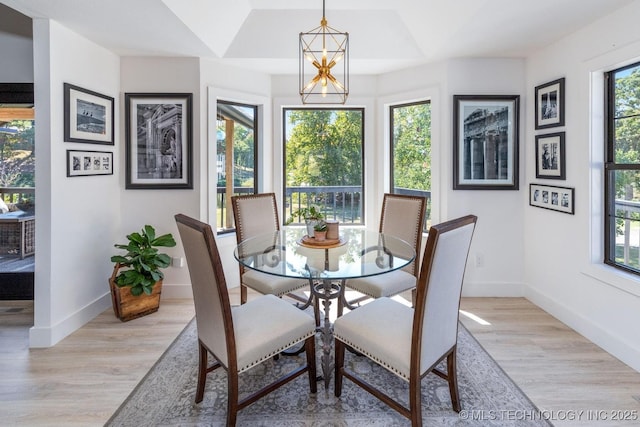 dining space featuring an inviting chandelier, plenty of natural light, and light wood-type flooring