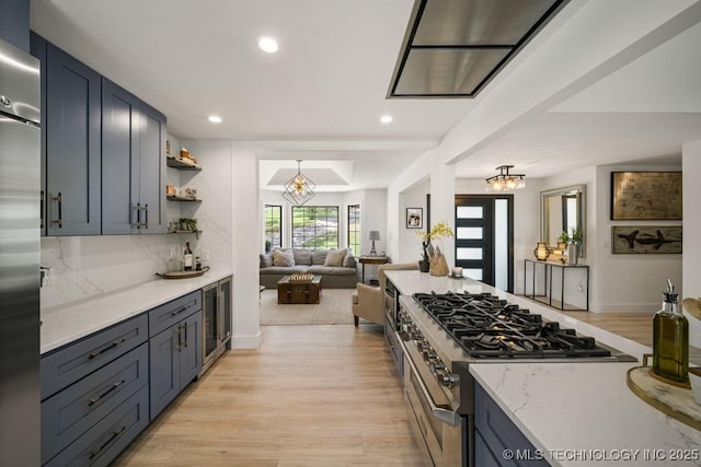 kitchen with beverage cooler, decorative backsplash, stainless steel appliances, light stone countertops, and light hardwood / wood-style flooring