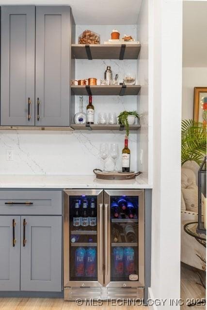 bar featuring gray cabinetry and beverage cooler