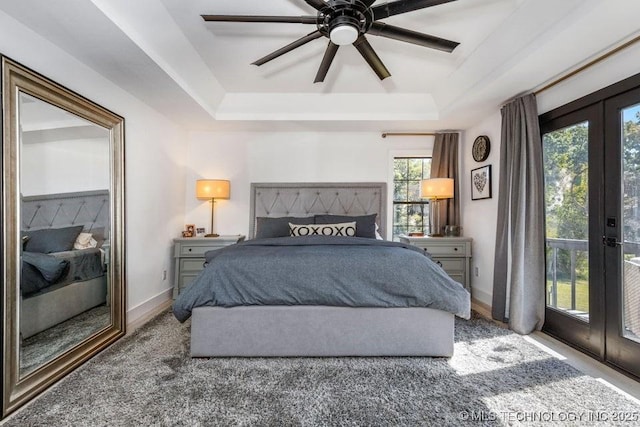 bedroom with a raised ceiling, access to exterior, ceiling fan, and french doors