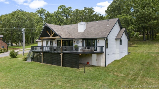 back of property featuring a wooden deck and a yard