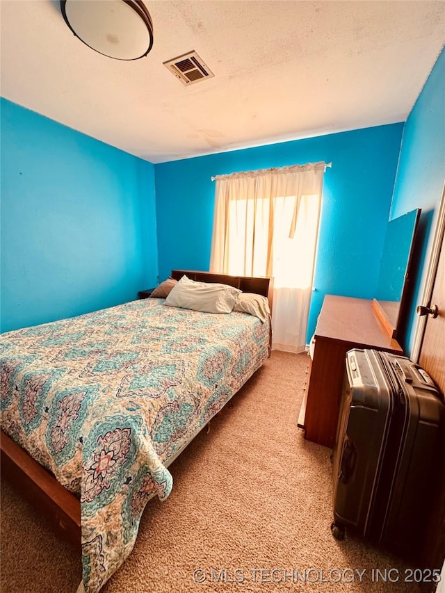 bedroom with light carpet and a textured ceiling
