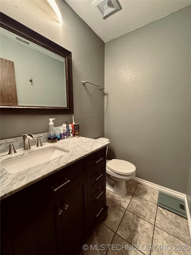 bathroom with vanity, tile patterned flooring, and toilet