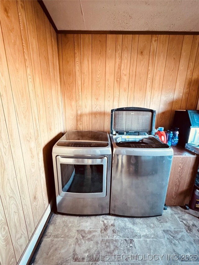 washroom featuring washing machine and clothes dryer and wooden walls