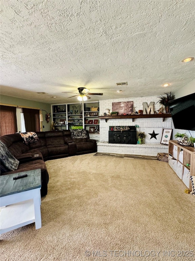 carpeted living room with ceiling fan, a brick fireplace, and a textured ceiling