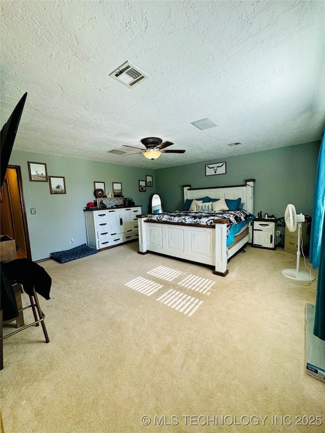 carpeted bedroom featuring ceiling fan and a textured ceiling