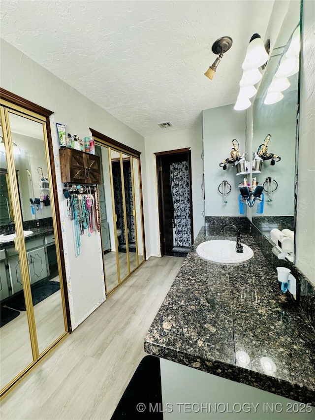 bathroom featuring vanity, hardwood / wood-style floors, and a textured ceiling