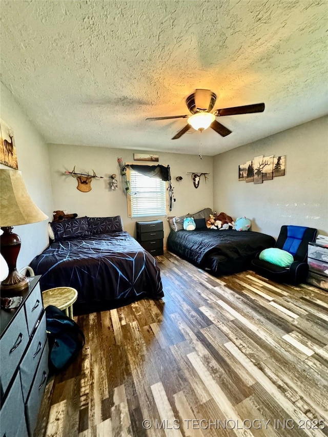 bedroom featuring hardwood / wood-style flooring, a textured ceiling, and ceiling fan