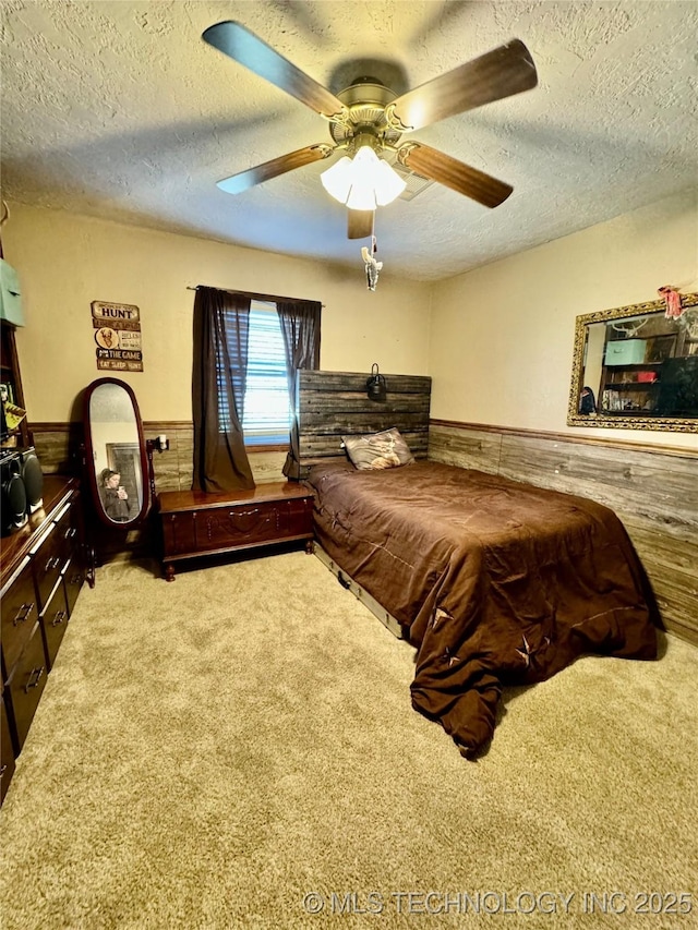 carpeted bedroom featuring a textured ceiling and ceiling fan