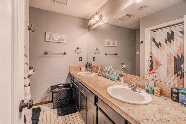 full bathroom featuring a textured wall, visible vents, and a sink