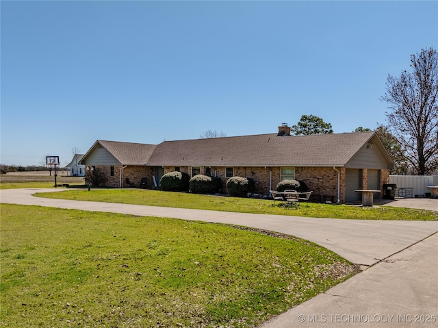 ranch-style house with brick siding, a chimney, concrete driveway, and a front lawn