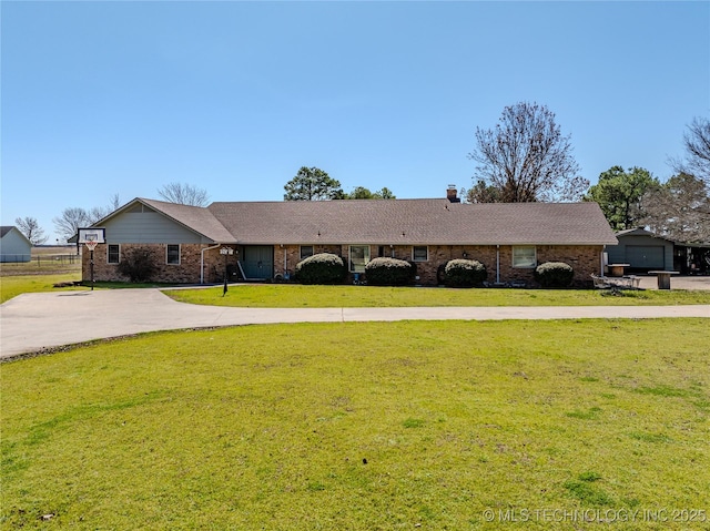 ranch-style house with brick siding, concrete driveway, a chimney, and a front lawn