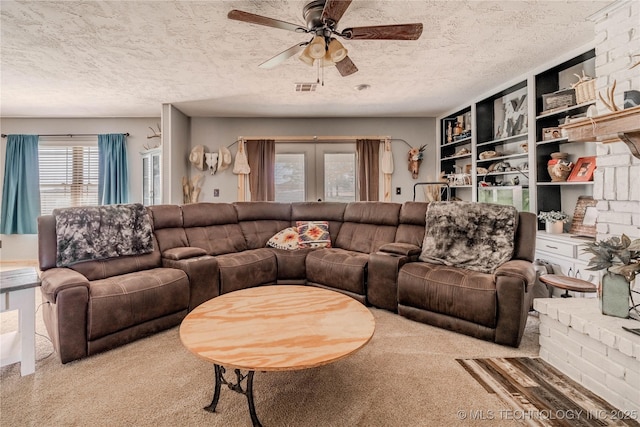 living area featuring visible vents, a textured ceiling, ceiling fan, and carpet floors