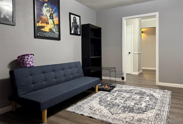 living area with wood-type flooring and a textured ceiling