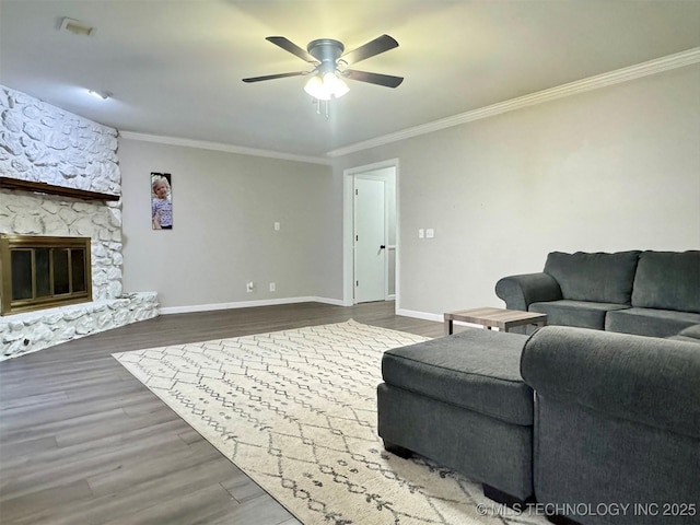 unfurnished living room featuring crown molding, a stone fireplace, hardwood / wood-style floors, and ceiling fan