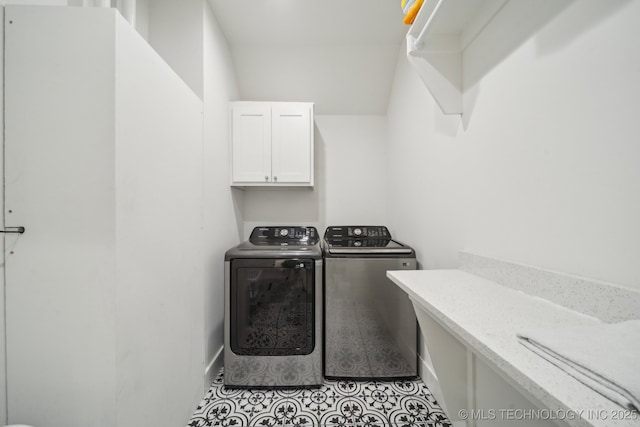 washroom featuring independent washer and dryer, cabinets, and light tile patterned floors