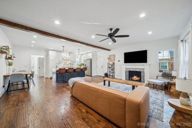 2508 E 16th St, Tulsa, OK 74104 - living room with recessed lighting, a fireplace, beamed ceiling, dark wood-type flooring, and ceiling fan
