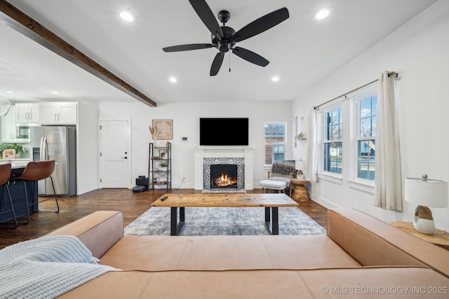 living room with beamed ceiling, dark wood-type flooring, and ceiling fan