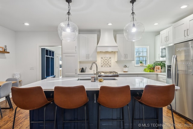 kitchen with custom exhaust hood, white cabinetry, pendant lighting, and stainless steel fridge with ice dispenser