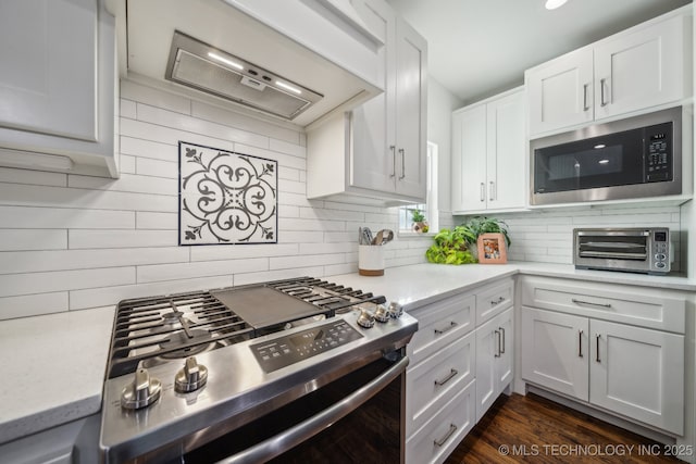 2508 E 16th St, Tulsa, OK 74104 - kitchen featuring built in microwave, stainless steel gas stove, decorative backsplash, white cabinetry, and extractor fan