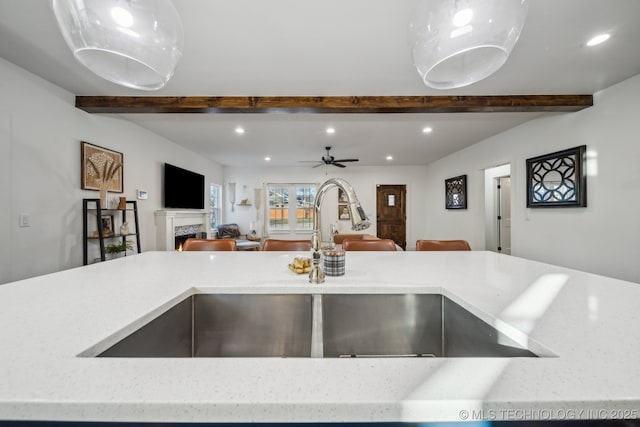 2508 E 16th St, Tulsa, OK 74104 - kitchen featuring beam ceiling, open floor plan, a sink, recessed lighting, and a lit fireplace