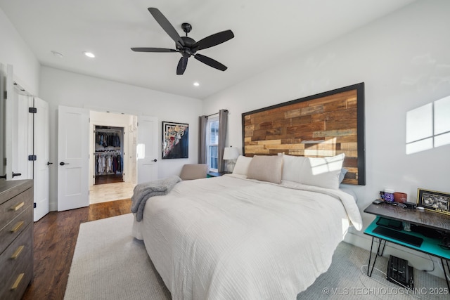 bedroom featuring dark wood-type flooring, a closet, and ceiling fan