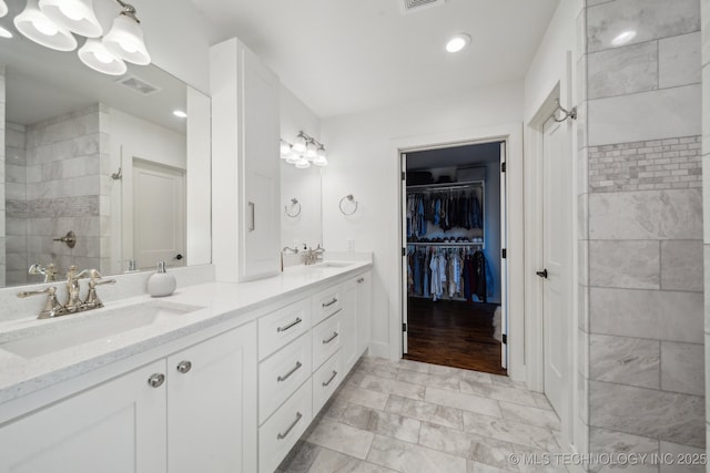 bathroom with vanity and tiled shower