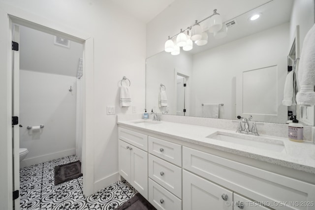 2508 E 16th St, Tulsa, OK 74104 - bathroom with double vanity, toilet, tile patterned flooring, and baseboards