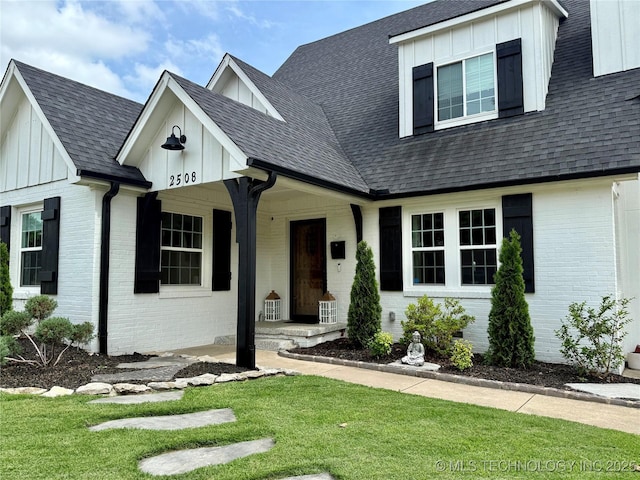 2508 E 16th St, Tulsa, OK 74104 - view of front facade featuring brick siding, board and batten siding, and a front yard