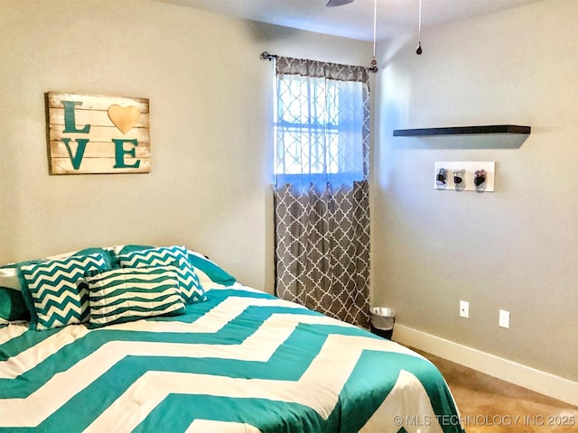 carpeted bedroom with ceiling fan and baseboards