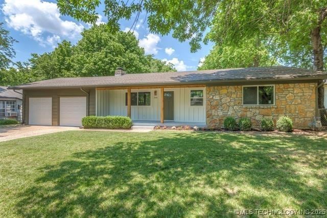 ranch-style home featuring a garage, a porch, and a front lawn