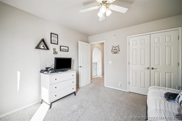 bedroom featuring light carpet, a closet, and ceiling fan