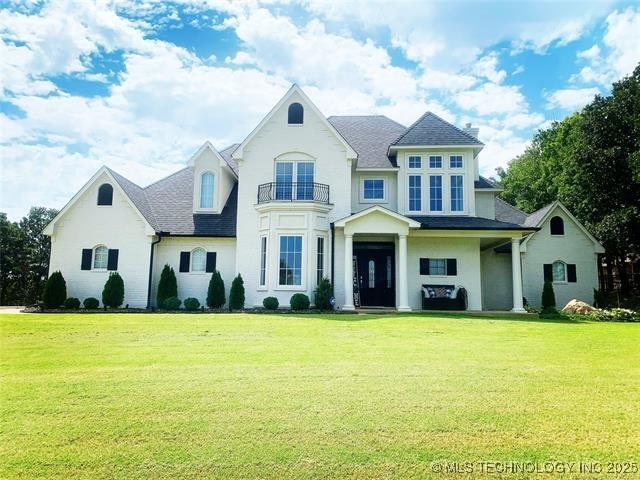 french country home featuring a front yard