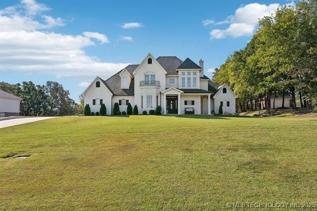 french provincial home with a front yard