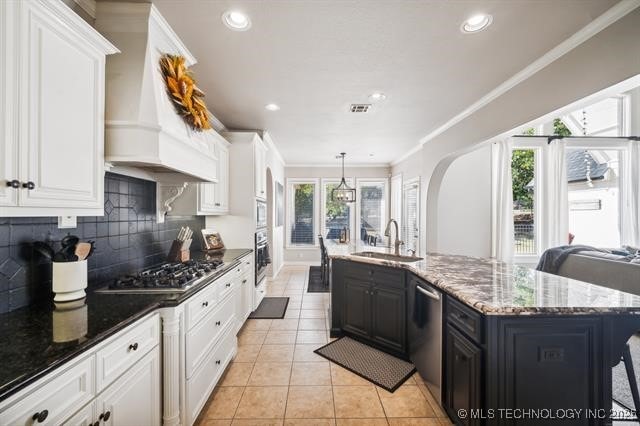 kitchen featuring sink, white cabinets, backsplash, custom exhaust hood, and light tile patterned floors