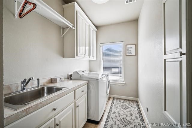 washroom featuring light tile patterned flooring, cabinets, sink, and washing machine and clothes dryer