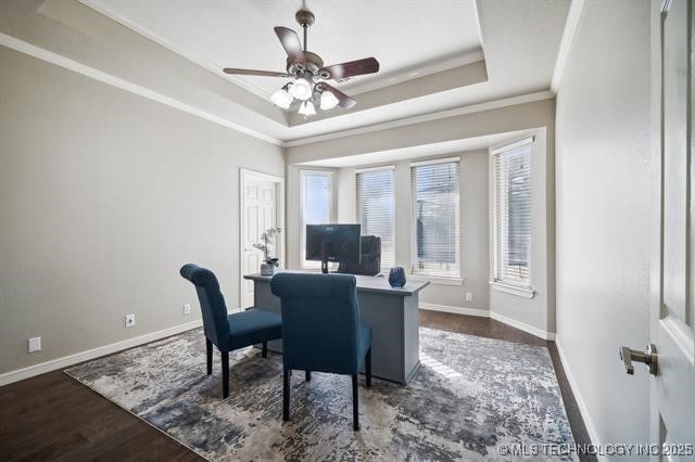 office with ornamental molding, dark hardwood / wood-style floors, ceiling fan, and a tray ceiling