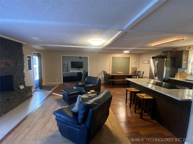 living room featuring a fireplace, wood-type flooring, sink, and a textured ceiling