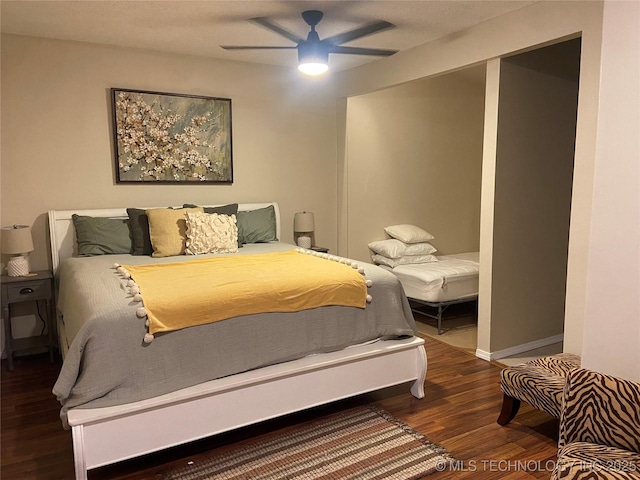 bedroom with dark hardwood / wood-style flooring and ceiling fan